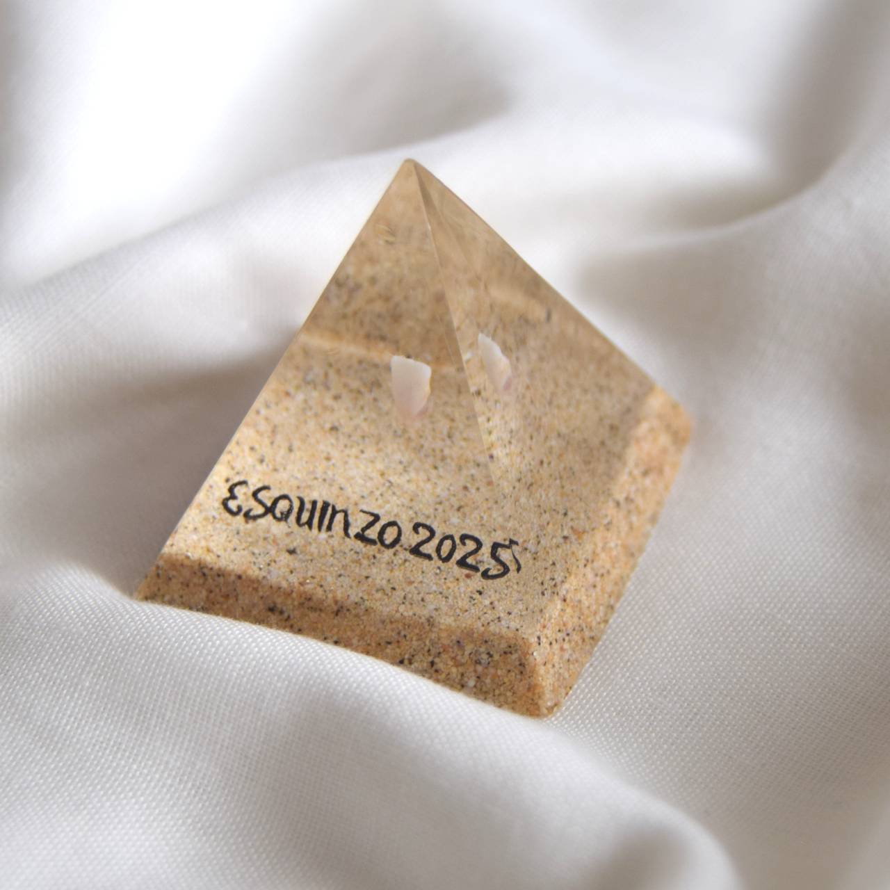 Pyramida s pískem z pláže a dětským zoubkem